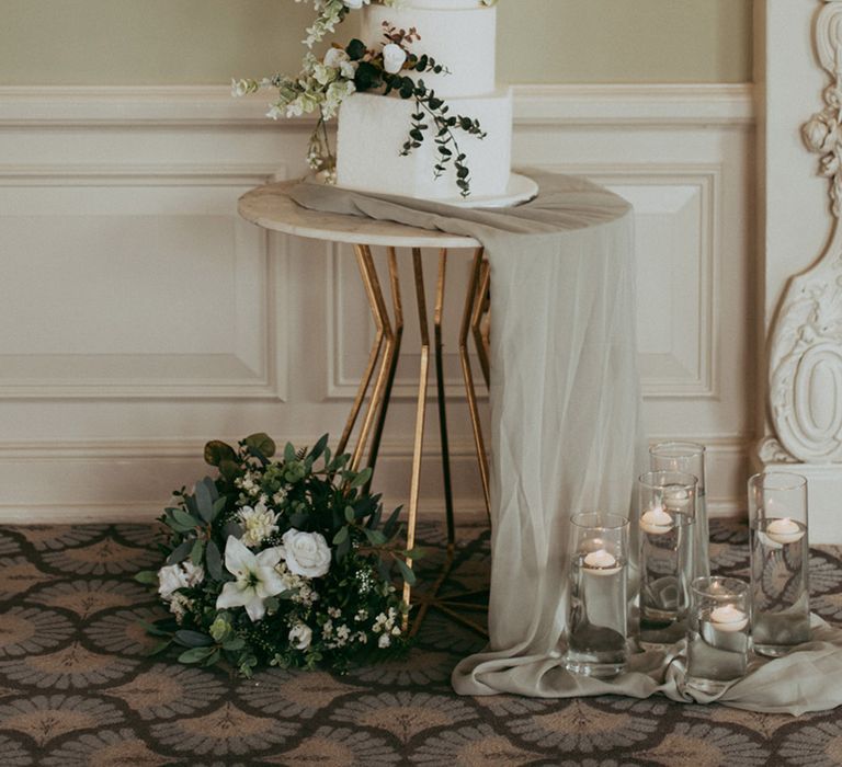 Classic white iced four tier wedding cake with faux white flower decorations 