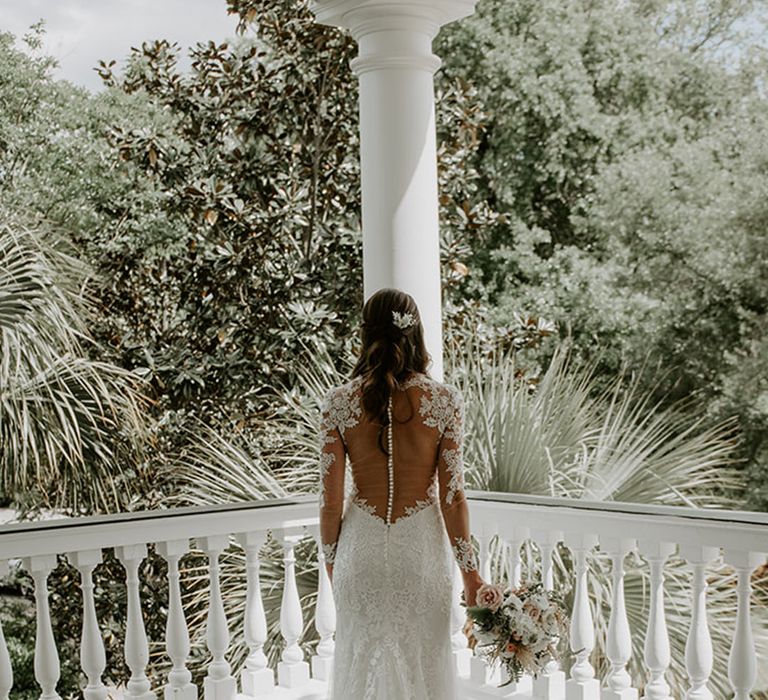 Bride in a long sleeve classic wedding dress with an illusion back button wedding dress