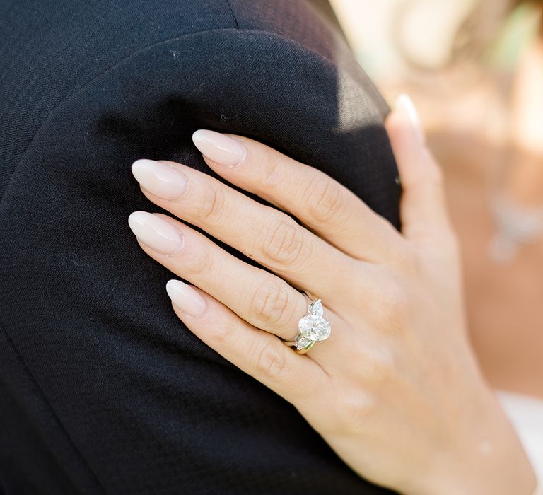 Bride wears neutral nail varnish and diamond engagement ring 