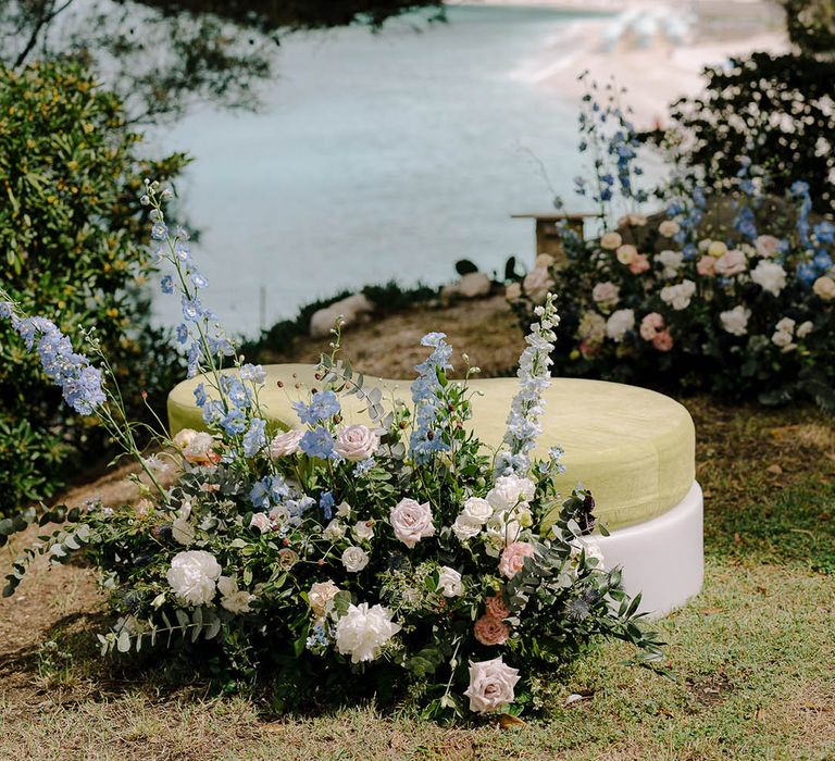 The View from the alter at Torre de Bosis wedding venue in Portonovo, Italy showing the sea and floral installations that include roses, wildflowers, thistles and beautiful blue flowers