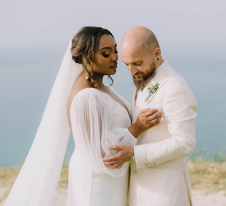 Bride and Groom hold each other in front of ocean view at destination wedding in Italy