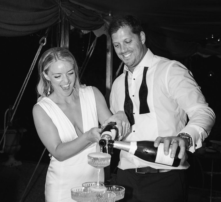 Bride and groom pour a champagne tower at their wedding 