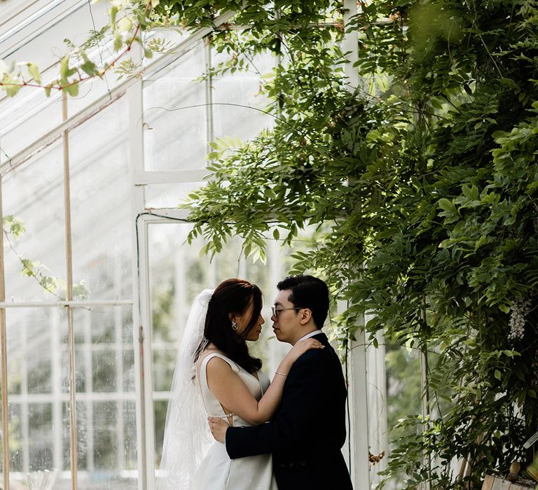 Bride & groom stand within greenhouse before Chinese Tea Ceremony at Carlowrie Castle