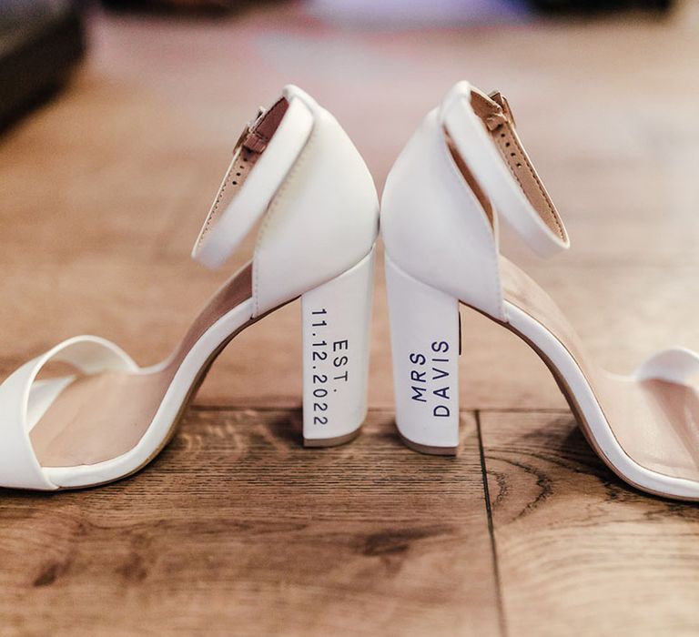 The bride's white block heel wedding shoes with personalisation on the heels 