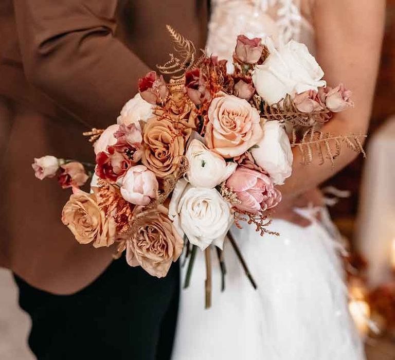 Bride holding dried blush garden rose, peony and dried flower bridal bouquet 