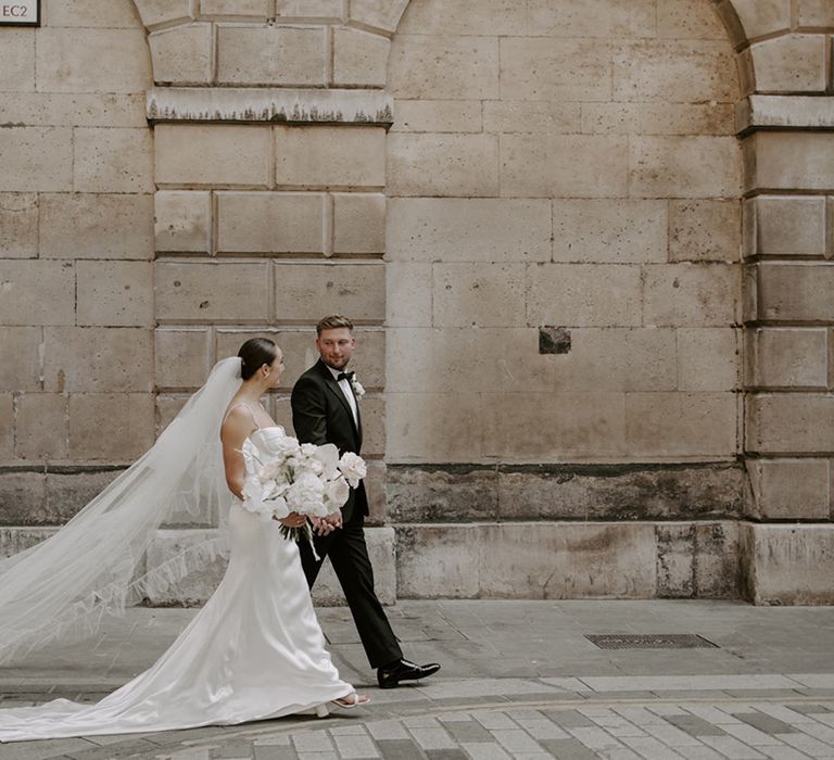 The bride and groom walk together for their modern and minimal style city wedding in London 