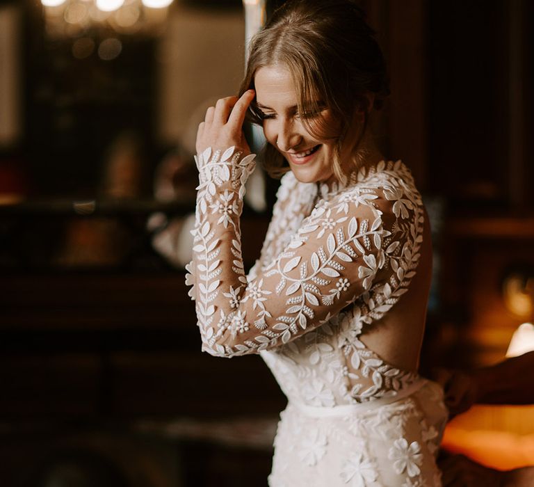 Bride in an elegant boho lace wedding dress embracing the groom in a velvet wedding suit 