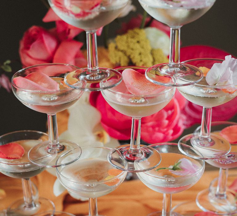 Rose petals in champagne coupe glasses in champagne tower 