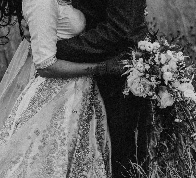 Black and white wedding photo of the bride and groom sharing an embrace