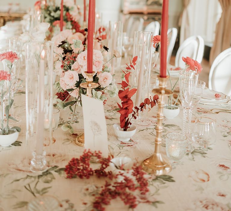 Red and white wedding tablescape with colourful candles and flowers 