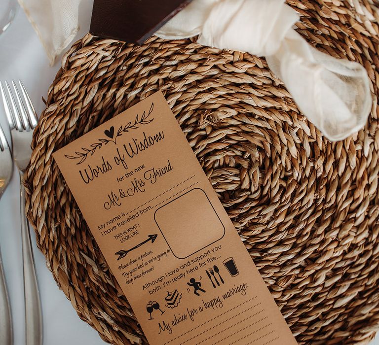 Wicker place mat with a sheer napkin, burgundy wedding place name and wedding game card