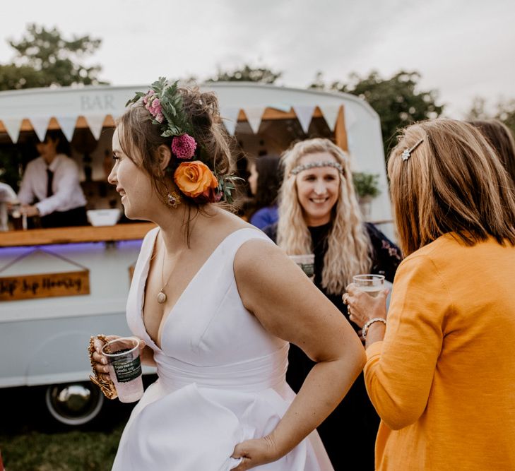 Bride with flower crown at outdoor wedding with street food van