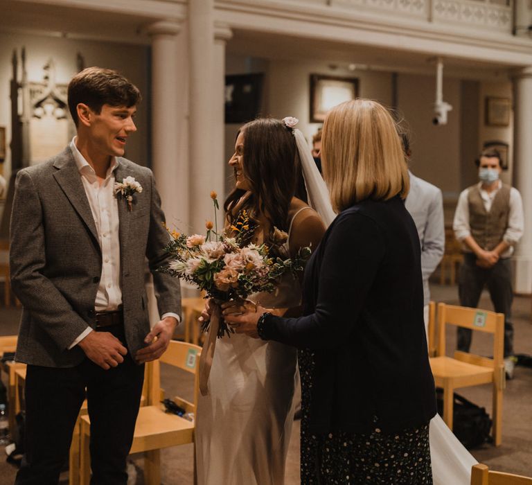 Mother of the bride giving her daughter away at the altar