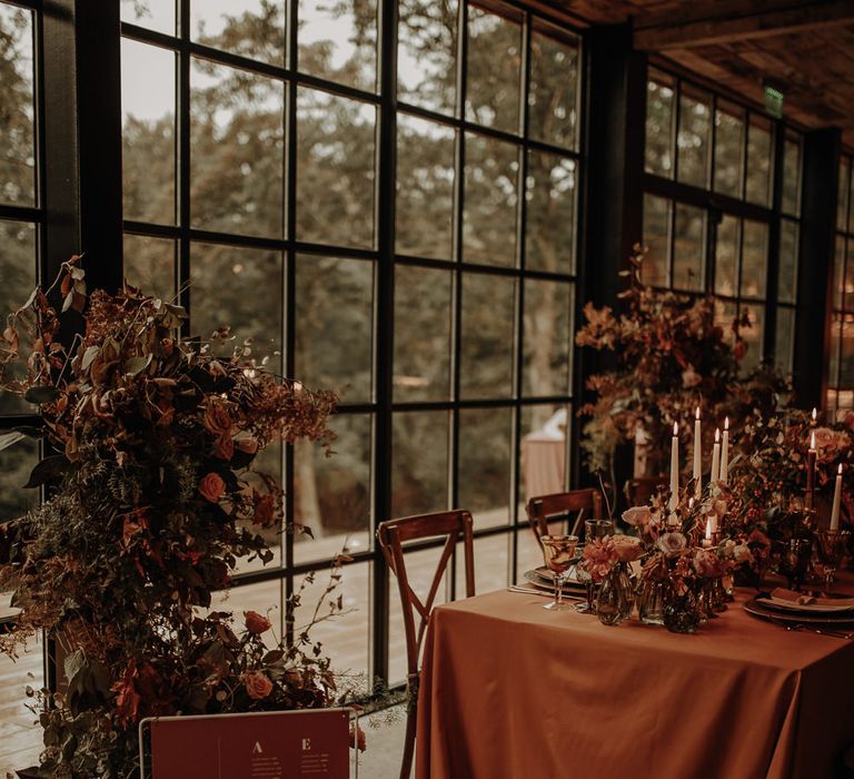 Rust coloured table plan on a white stand for intimate wedding 