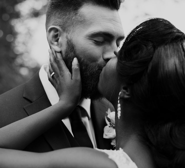 Black and white bride and groom portrait of them kissing 