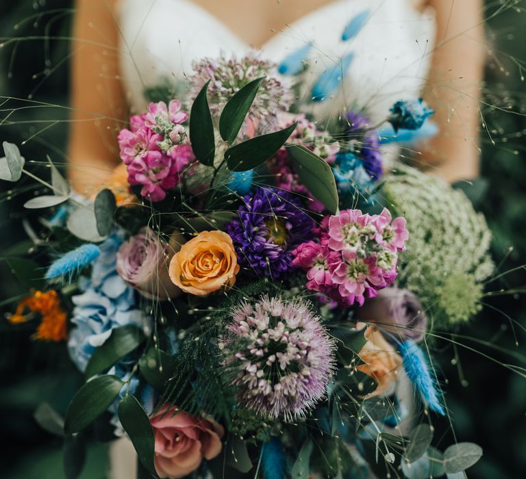 Bright and colourful bouquet of assorted flowers with blue, orange, purple, pink details