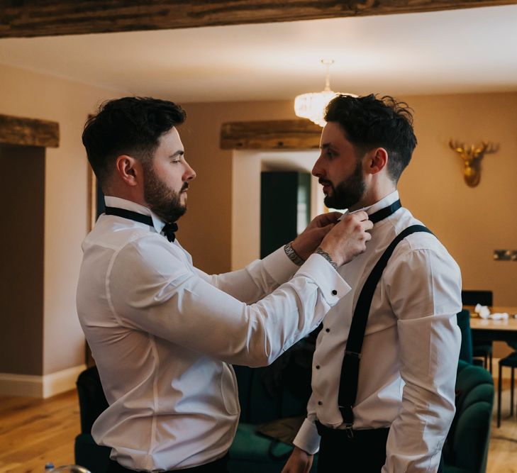 Groom on the wedding morning putting his bow tie on 