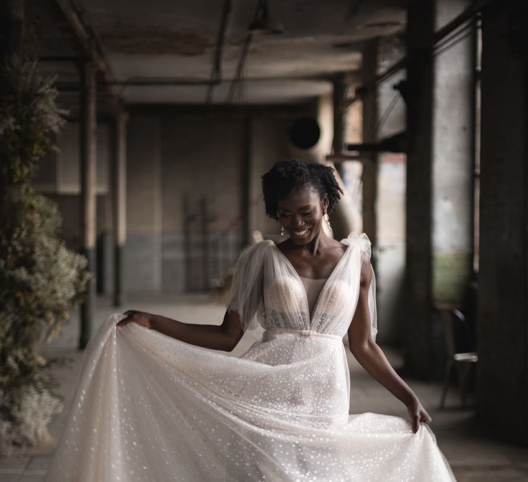 Bride in Berta sequinned wedding dress dancing in an industrial wedding venue 