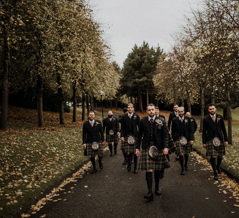 Groomsmen in kilts pose outside at highland wedding in Glencoe