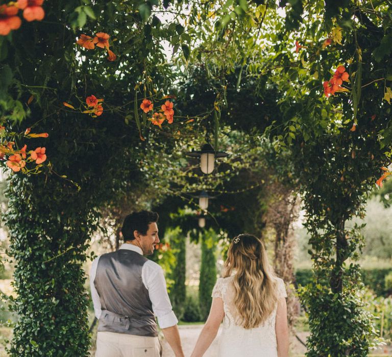 The bride and groom walk through the gardens of Le Mas De La Rose