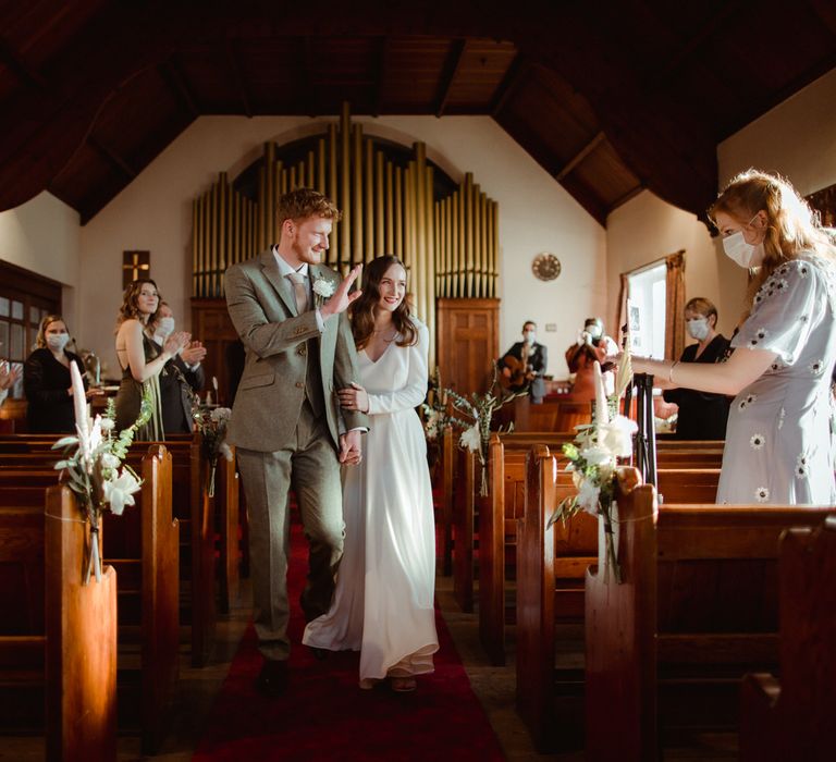 The bride and groom walking down the aisle at their Methodist wedding ceremony