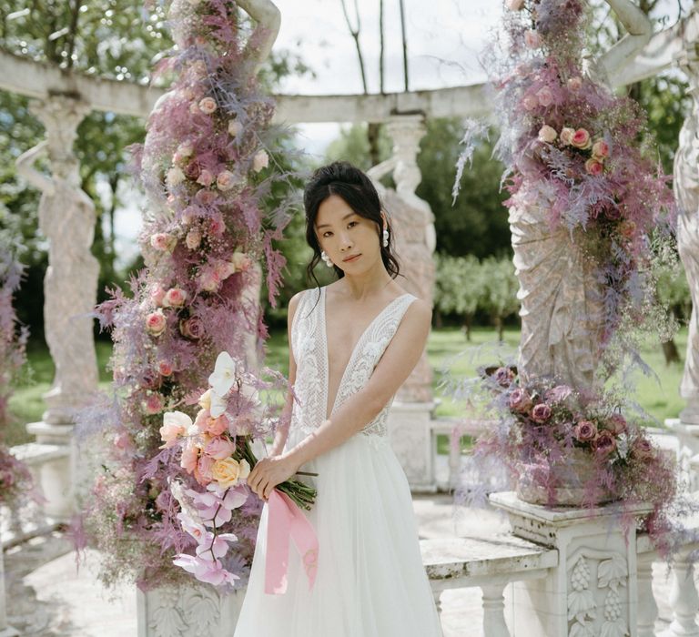 Bride stands surrounded by lilac florals in bandstand