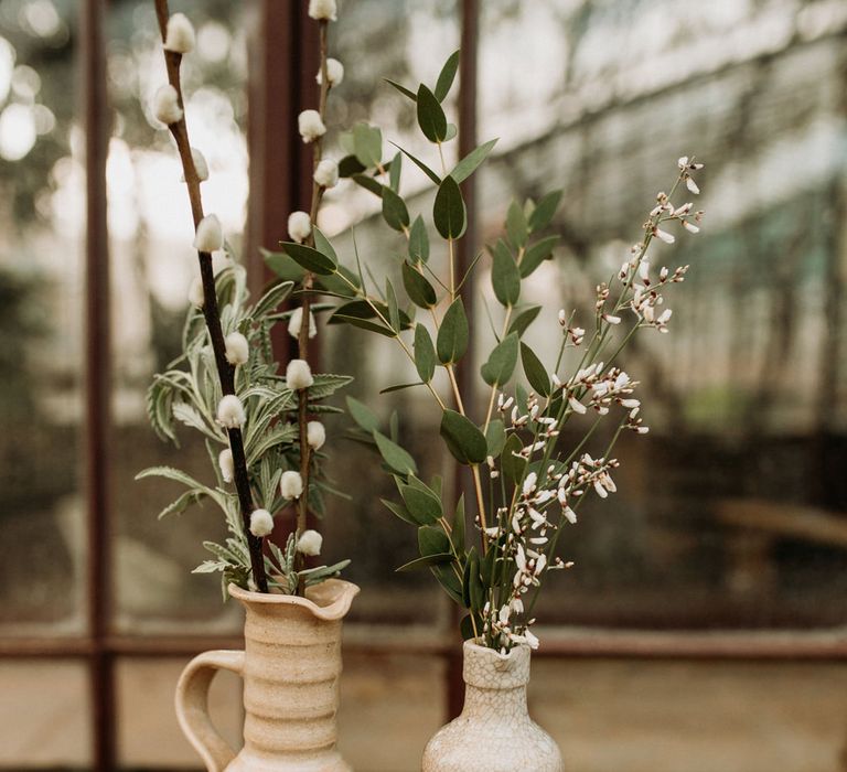 Flower stems in bottles, jugs and ink wells 