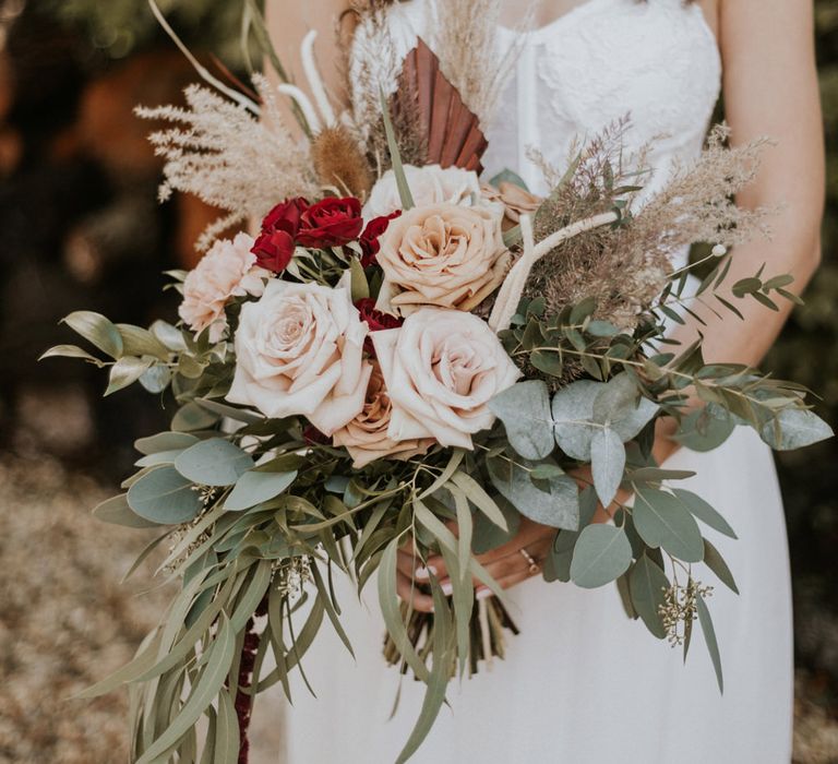 Wedding bouquet with pink and red roses, pampas grass and eucalyptus 