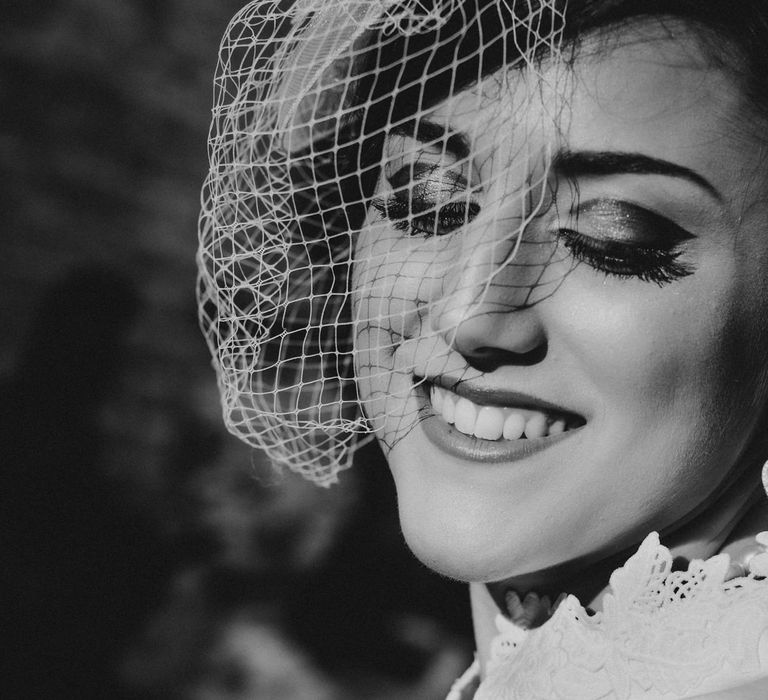 Black and white Hollywood glamour style close up photo of the bride's face with 1960s inspired makeup and pearl earrings