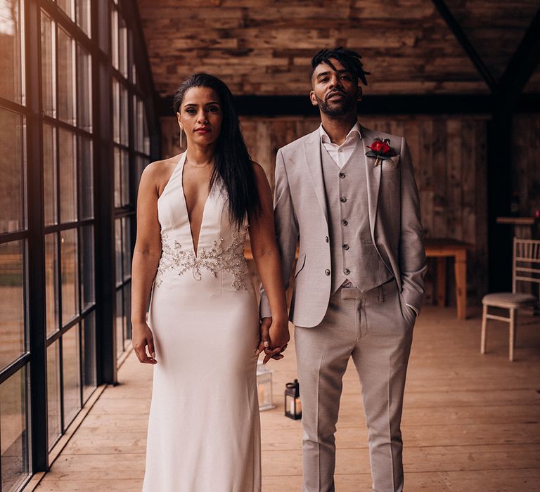 Bride & groom stand together on wedding day side by side 