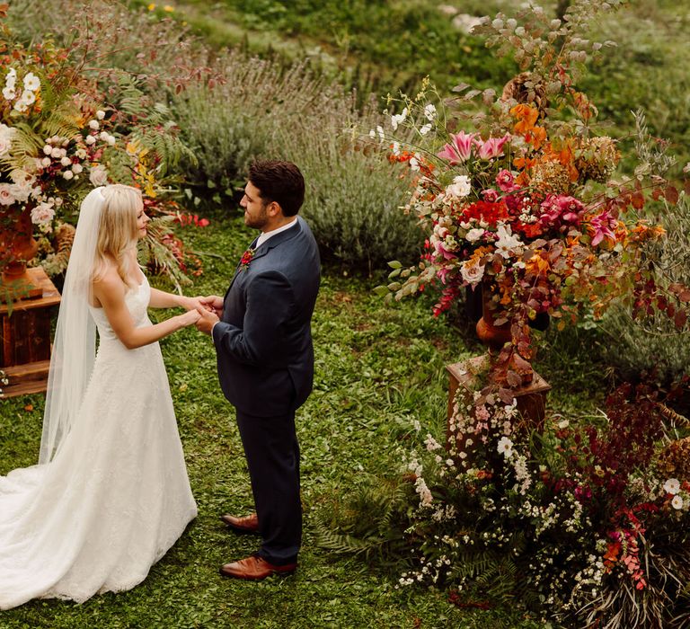 The bride and groom standing at the altar at their Italy elopement in an olive grove in Tuscany