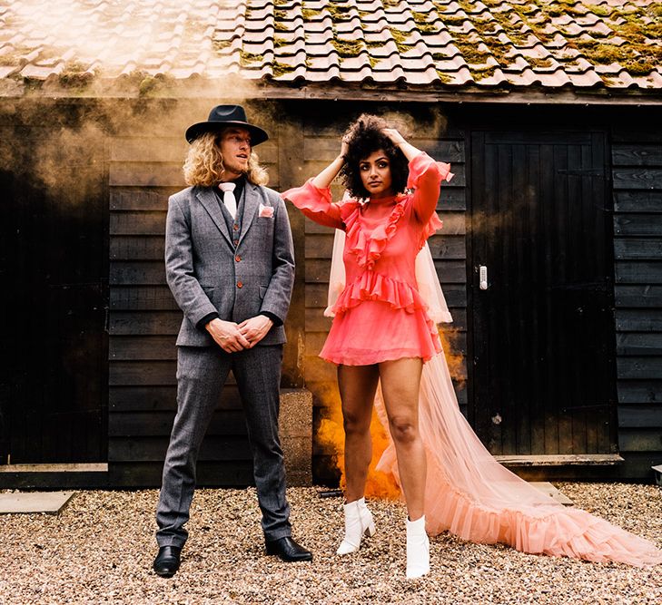 Orange grey smoke bomb portrait at Canary Shed with groom in a grey suit and bride in a short red dress and long pink veil 