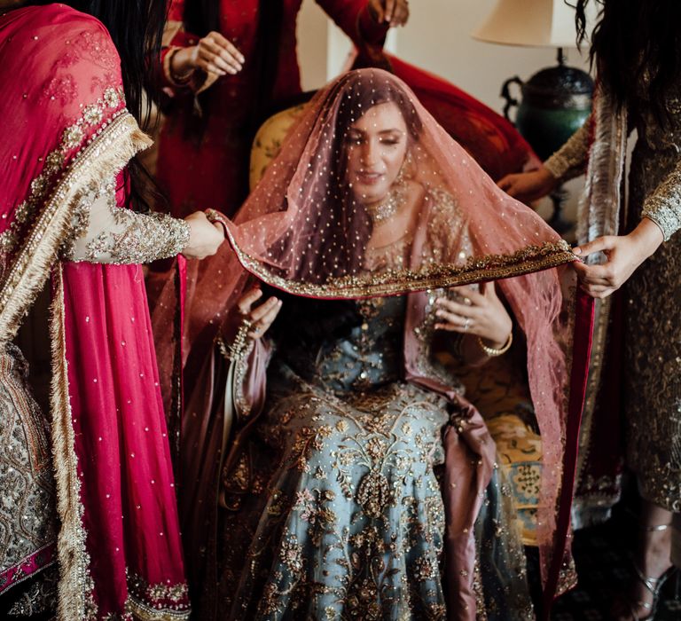 Wedding party lift veil above brides head as she gets ready