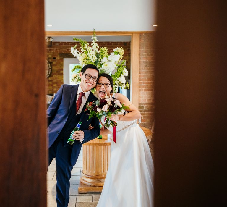 Bride & groom smile through doorway on their wedding day