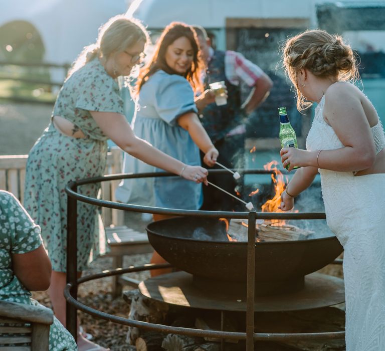 Paella is cooked in large skillet outdoors whilst guests watch 