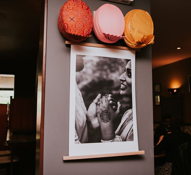 A print of an engagement shoot photo hangs at a wedding venue as decor. 