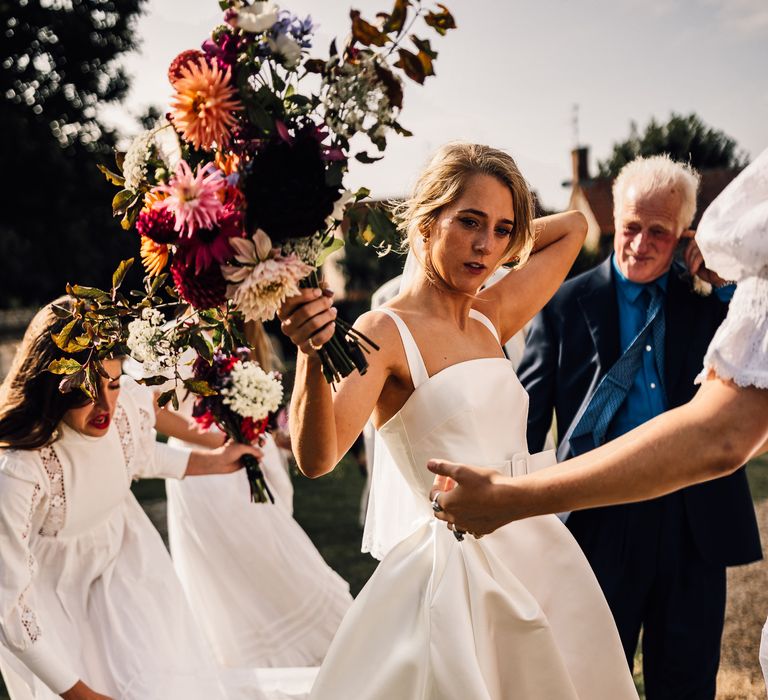 Bride clutches bright floral bouquet 