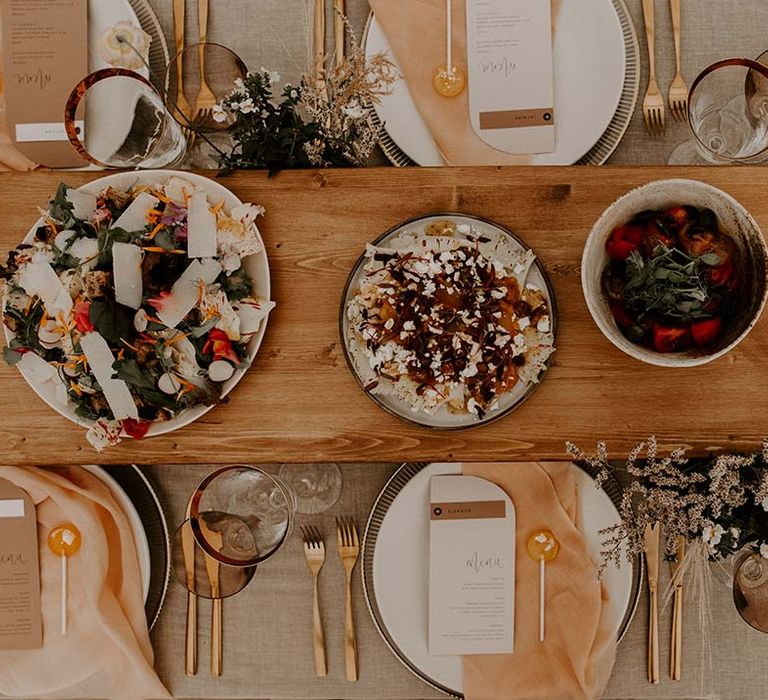 Wedding reception table place settings and catering doubling up as centrepiece decor 