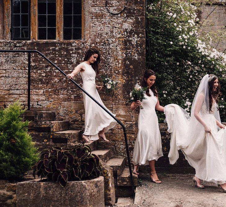 Bridesmaids in white satin midi dresses at elegant monochrome wedding 