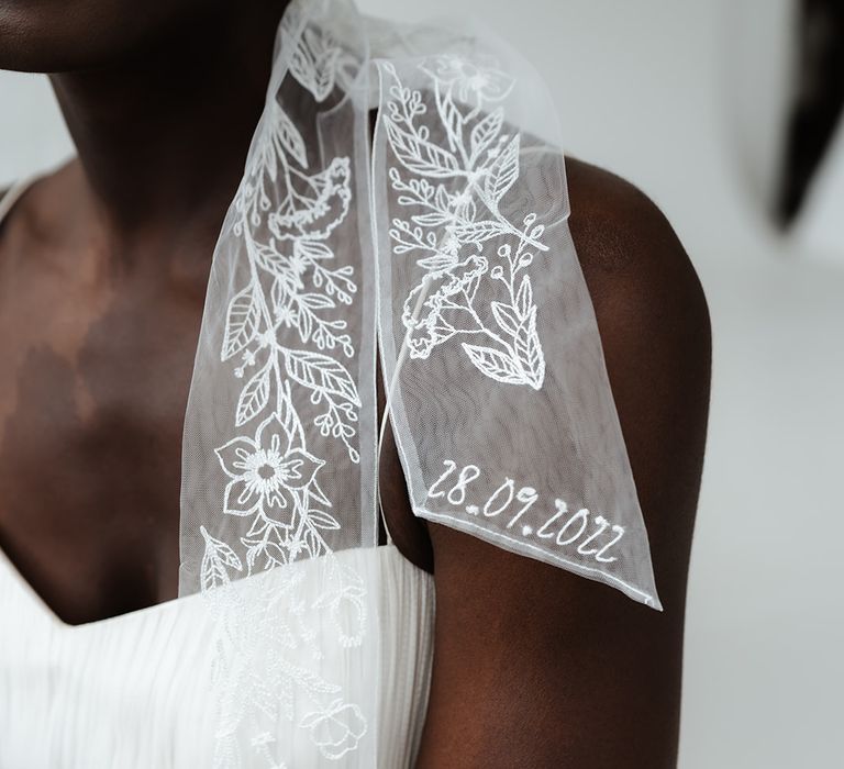 Black bride in a strapless wedding dress wearing a bow embroidered and personalised veil by Rebecca Anne Designs 