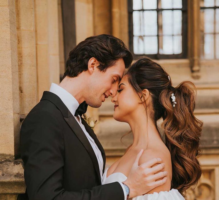 Intimate bride and groom portrait with groom in a tuxedo and bride in a strapless wedding dress with puff sleeves