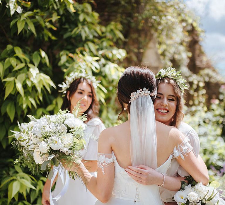 Bride hugs her bridesmaids on her wedding day