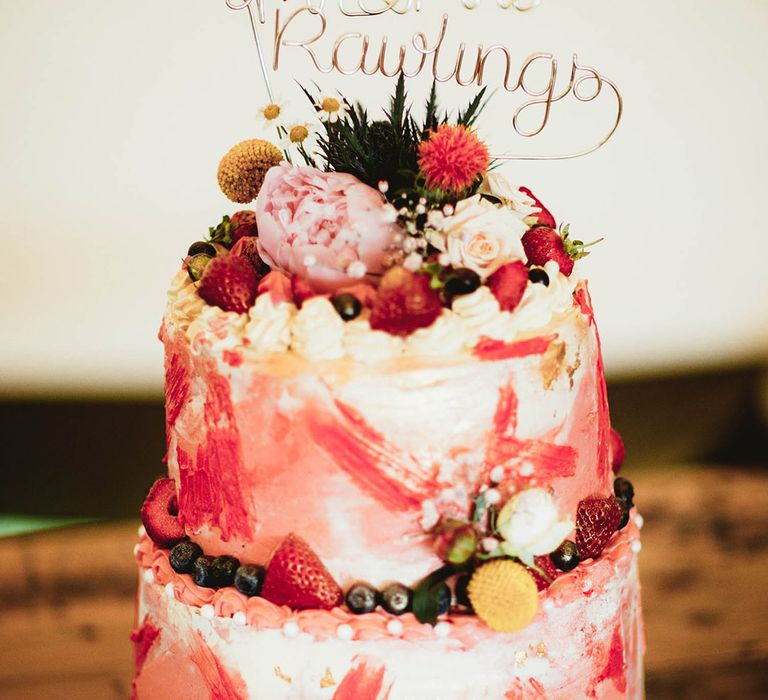 Pink wedding cake complete with hints of gold leaf and strawberries 