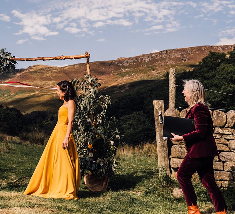 Bride & groom stand in front of rolling hills outdoors