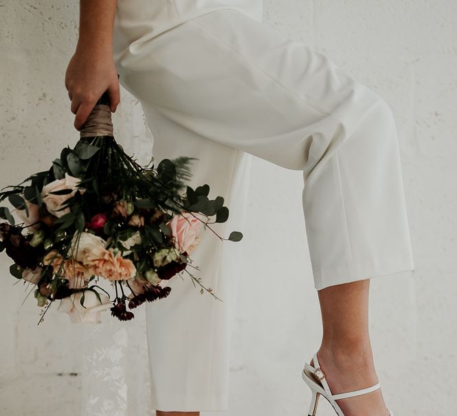 Bride places her foot on disco ball whilst wearing strappy heels