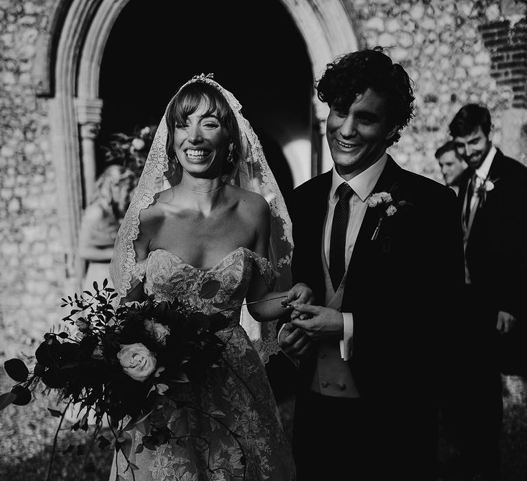 Bride and groom beam after church ceremony before they head to Oxnead Hall