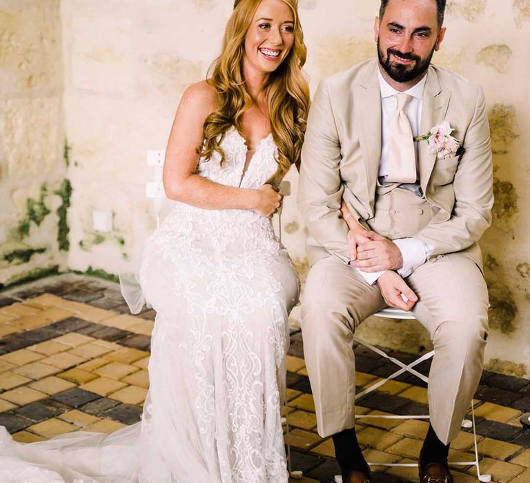 Bride & groom sit with one another during ceremony on their wedding day