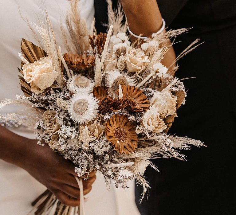 Bride holds dried floral bouquets