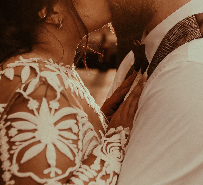 Golden hour portrait of bride and groom kissing 