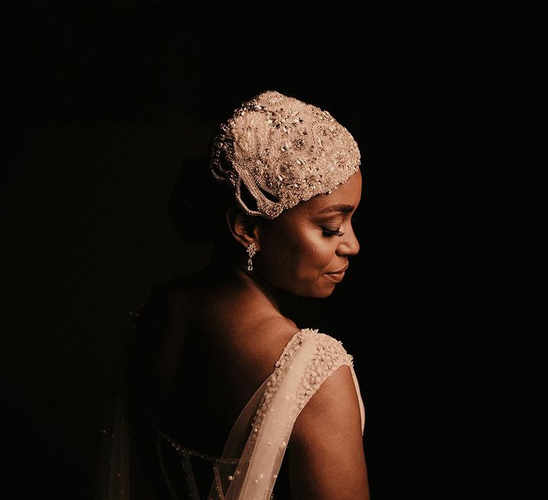 Black bride in a Pronovias wedding dress with Watteau train and beaded cap headdress 